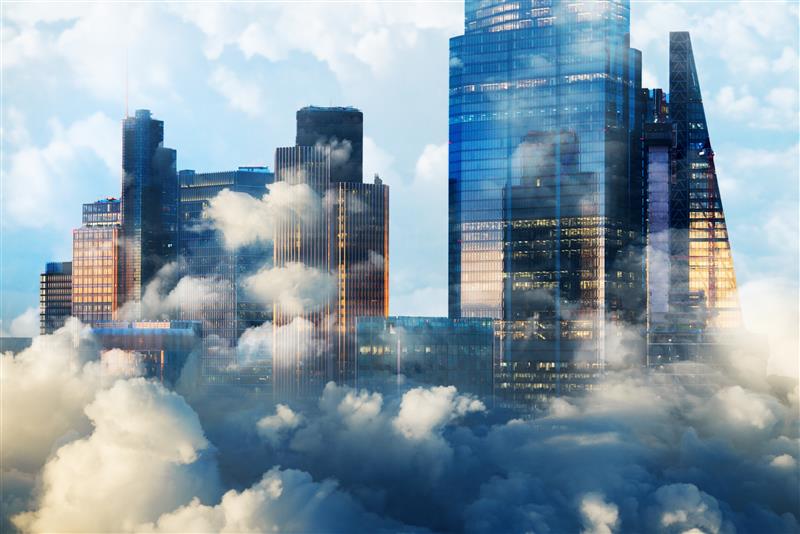 City skyline with modern office buildings partially obscured by clouds.