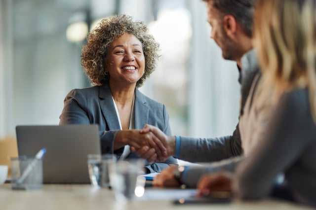 Profissional cumprimentando cliente em reunião de negócios durante encontro da rede de consultores