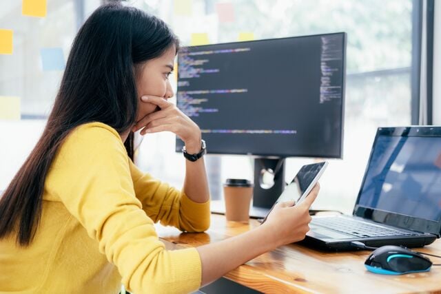 Analista de ciberseguridad revisando resultados de pruebas de penetración en dos pantallas.